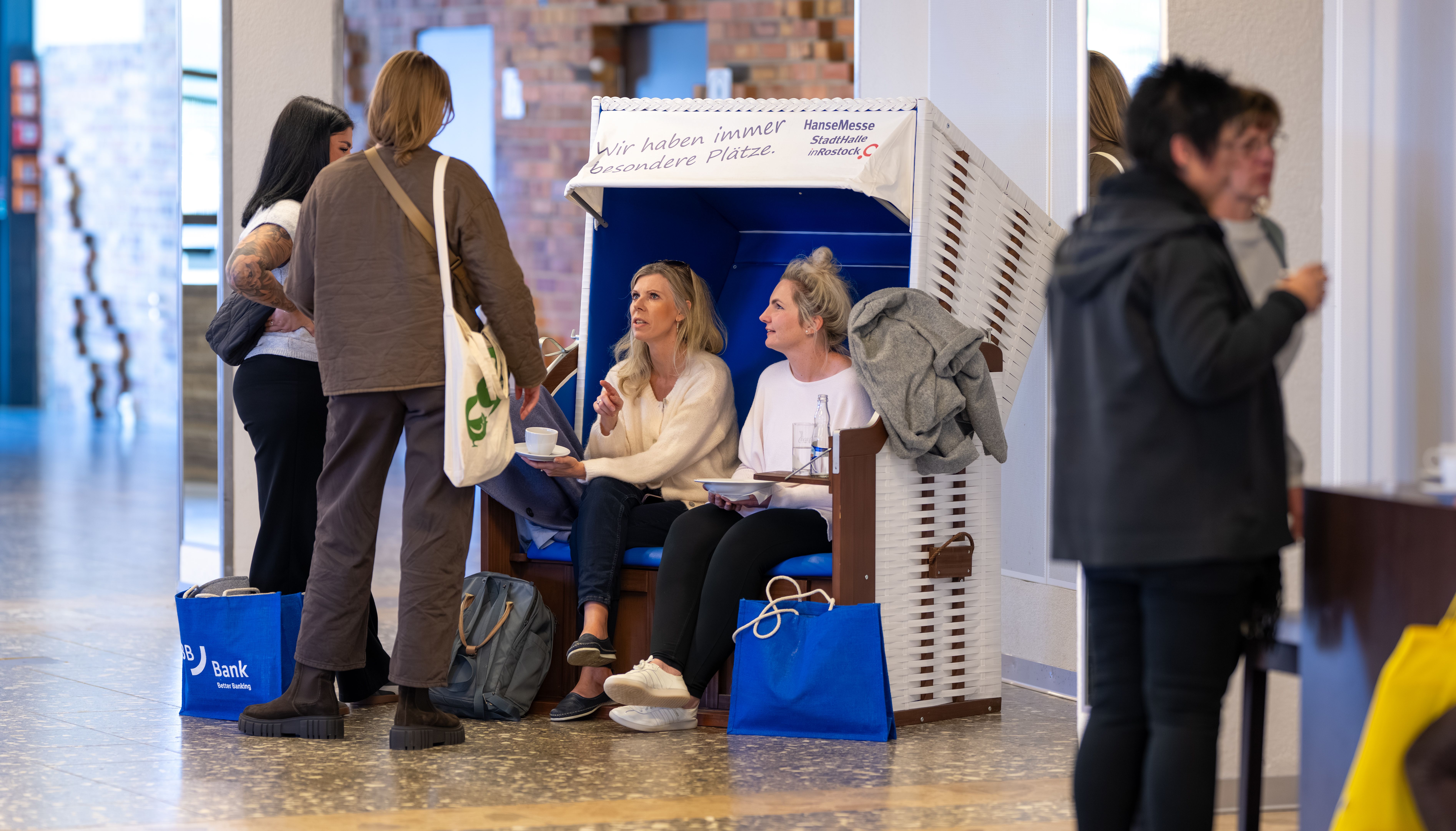 Lehrkräfte sitzen und stehen an einem Strandkorb