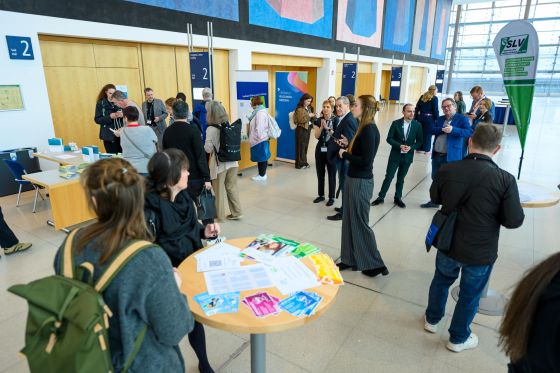 Lehrkräfte stehen im Foyer vor dem Vortragsraum und unterhalten sich