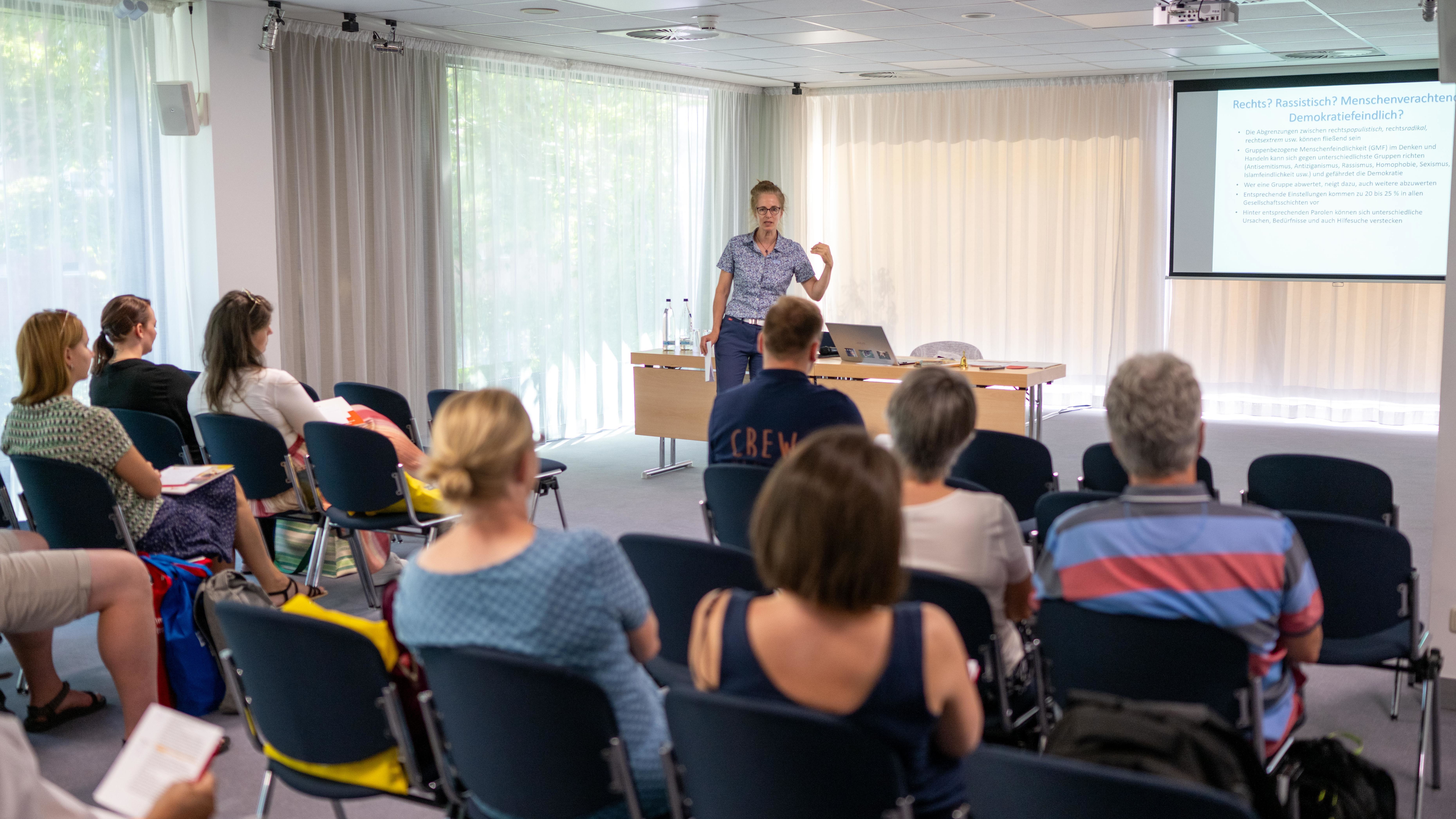 Ein Referent hält einen Vortrag in einem gefüllten Seminarraum