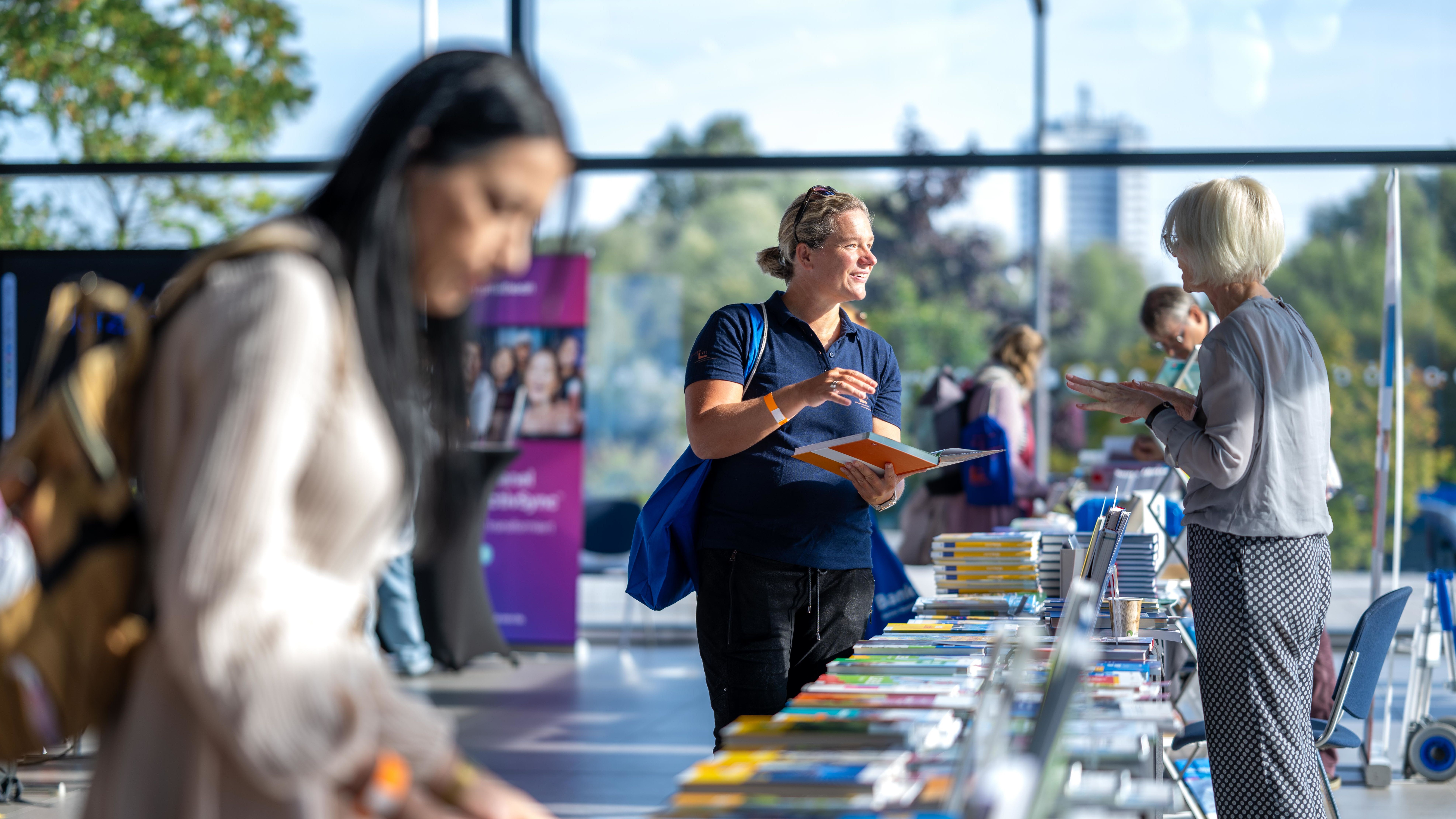 Teilnehmende informieren sich an den Ständen der Aussteller